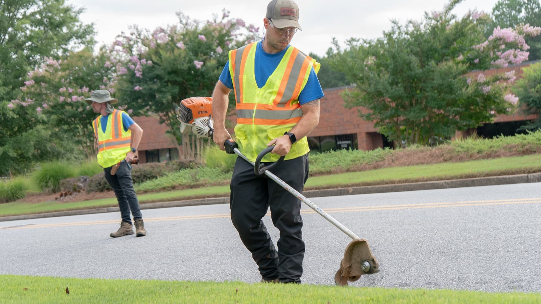 Tri Scapes crew edging a commercial streetscape in hi-vis PPE